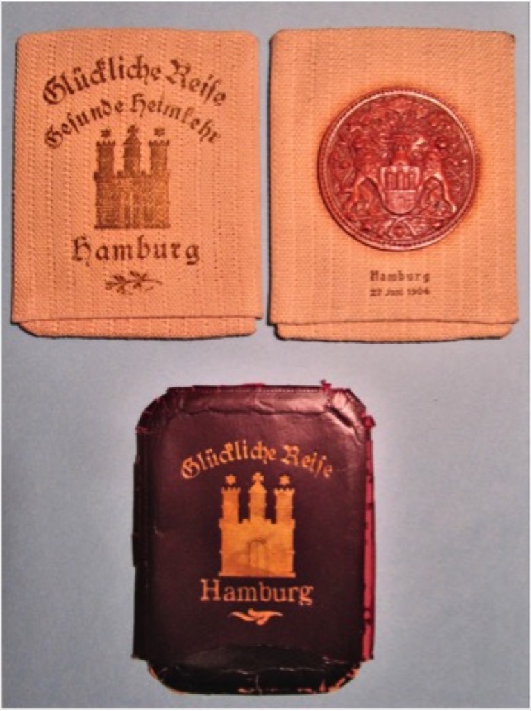 Três bolsas para charutos, em que se podem ler as mensagens "Boa Viagem" e "Um regresso a casa de boa saúde". Fonte: © Arquivo Estatal de Hamburgo: 111-1 Senat (séc. XII - séc. XX), Nr. 47053. Fotografia: Jan Kawlath 2019
